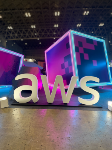 AWS Summit Japan 2026会場に設置されたAWSロゴのオブジェとネオンカラーに照らされた大型キューブのフォトスポット